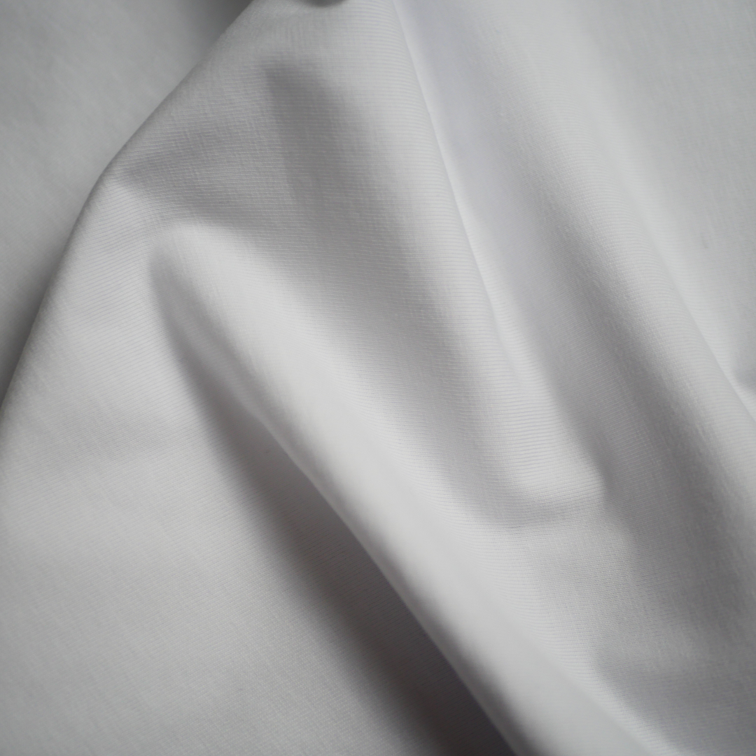タンギアーツ白のレディースモダンロゴサスティナブルTシャツ - 生地のクローズアップ